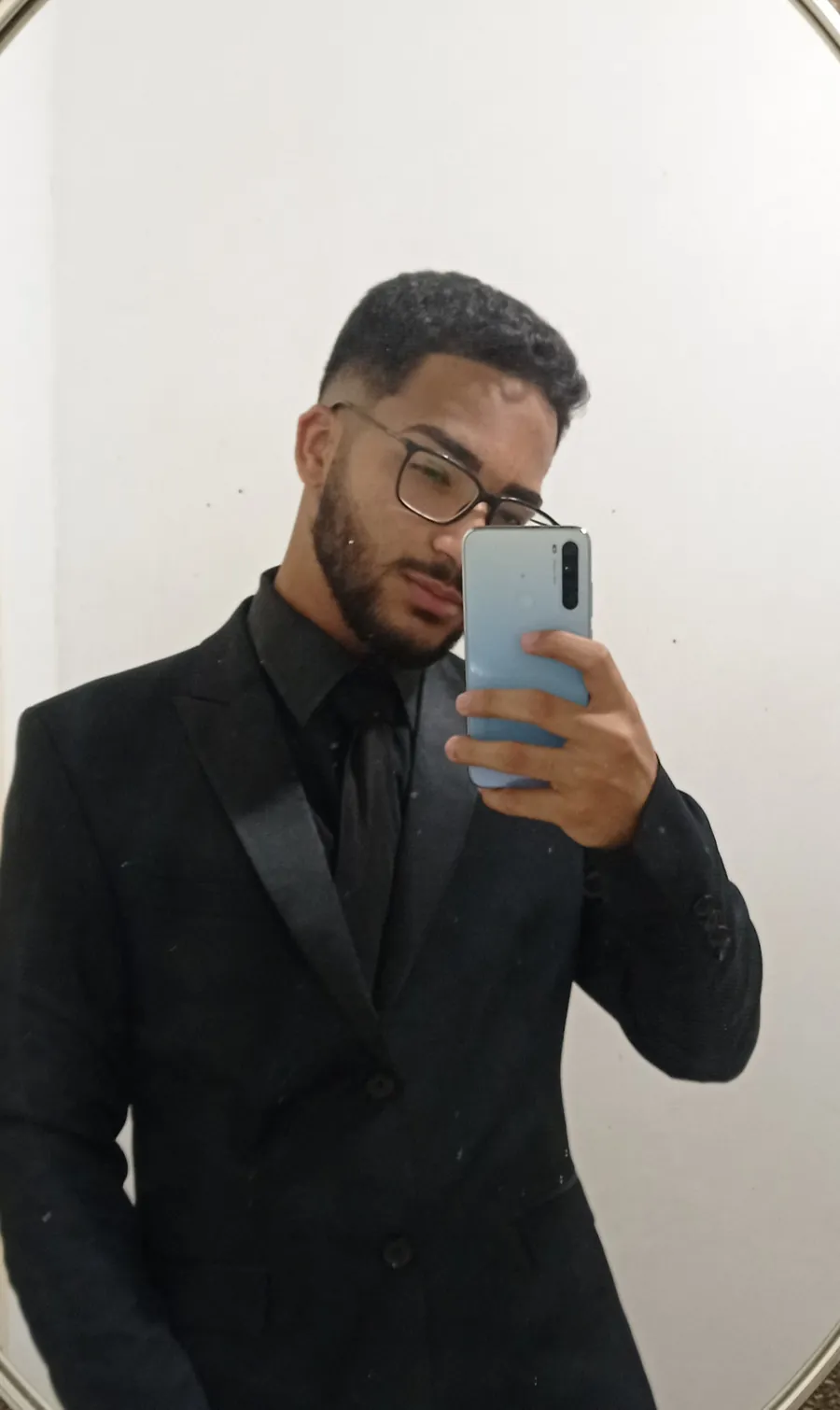 Daniel P Francisco de terno preto, em uma foto no espelho